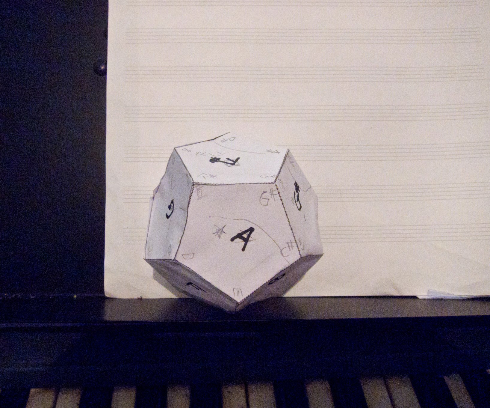 Dodecahedron on piano with staff paper
